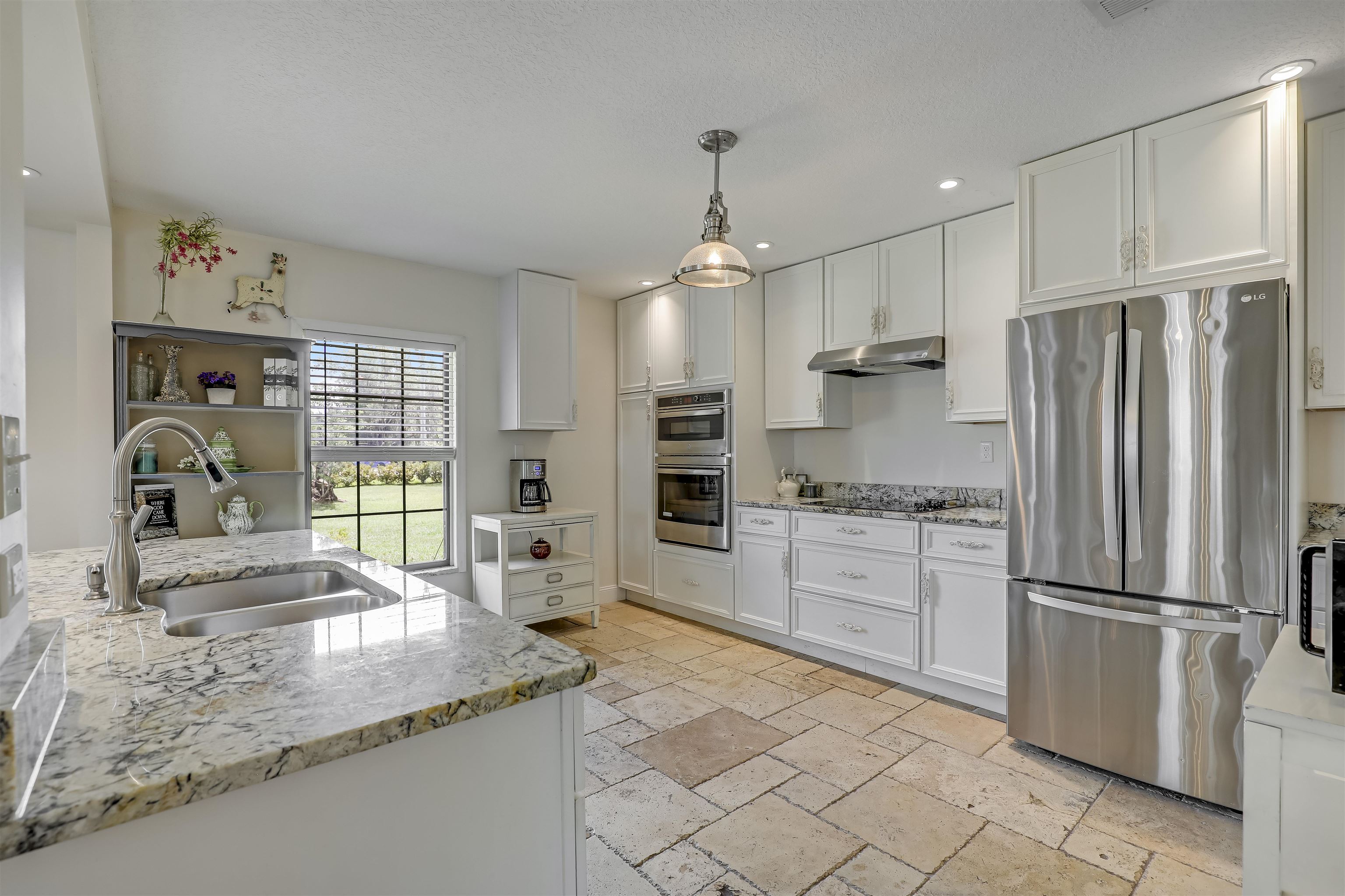 4485 Highway 16 St. Augustine, FL 32092 - Photo 20 of 59 a kitchen with granite countertop a refrigerator oven a sink and white cabinets