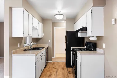 a kitchen with stainless steel appliances a stove a sink a refrigerator a microwave a sink and cabinets