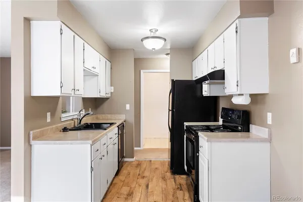 a kitchen with stainless steel appliances a stove a sink a refrigerator a microwave a sink and cabinets