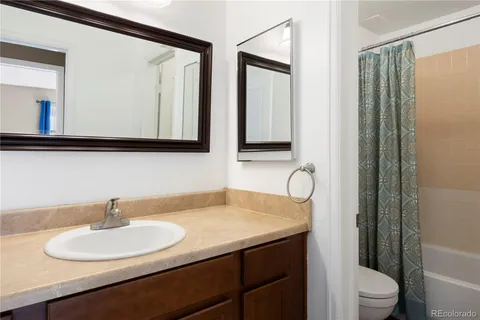 a bathroom with a sink vanity mirror and toilet