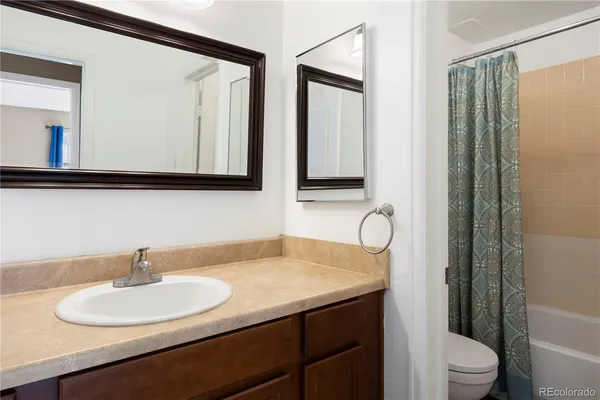 a bathroom with a sink vanity mirror and toilet