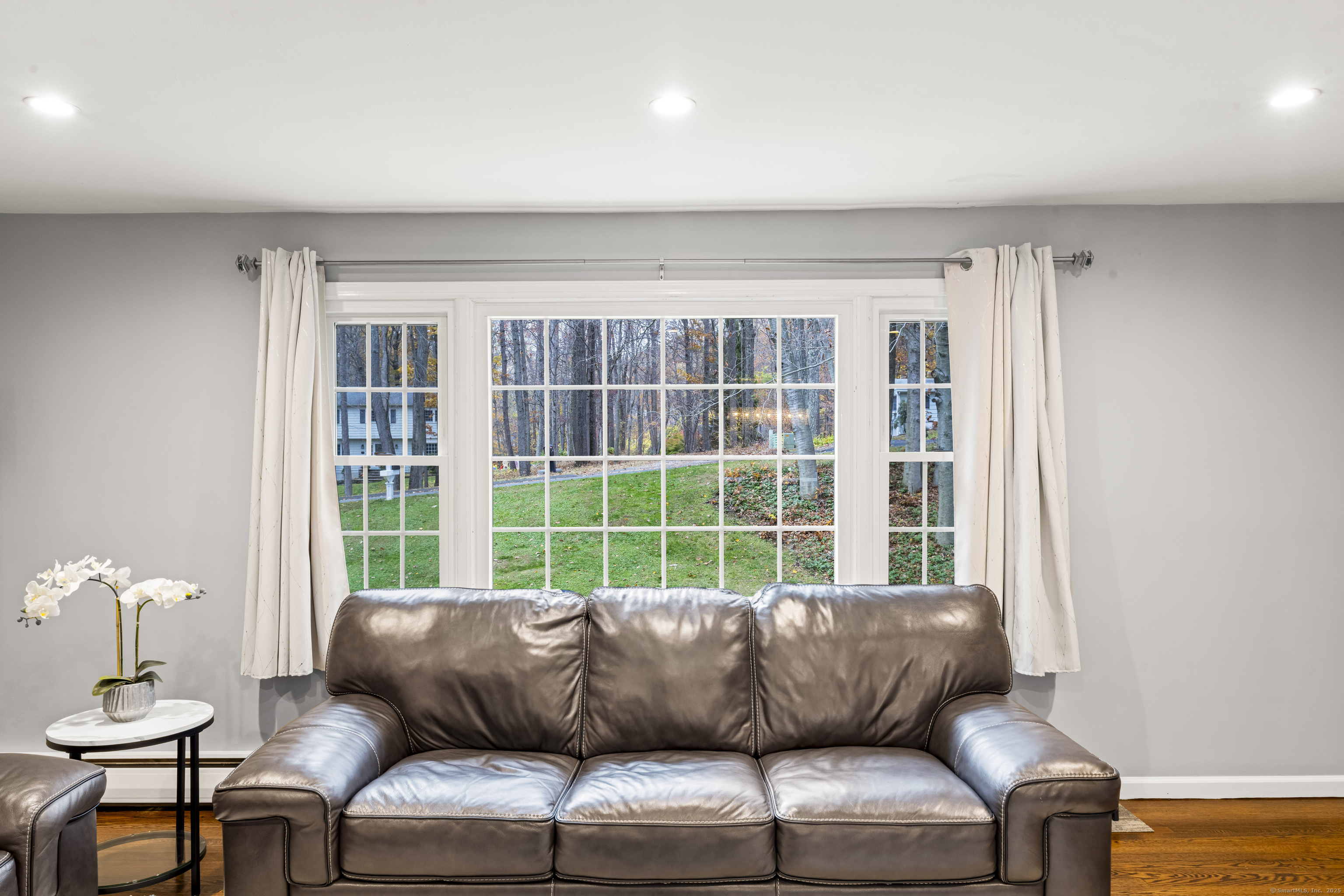 8 Possum Ridge Road Newtown, CT 06470 - Photo 8 of 38 a blue couch sitting in a living room next to a window