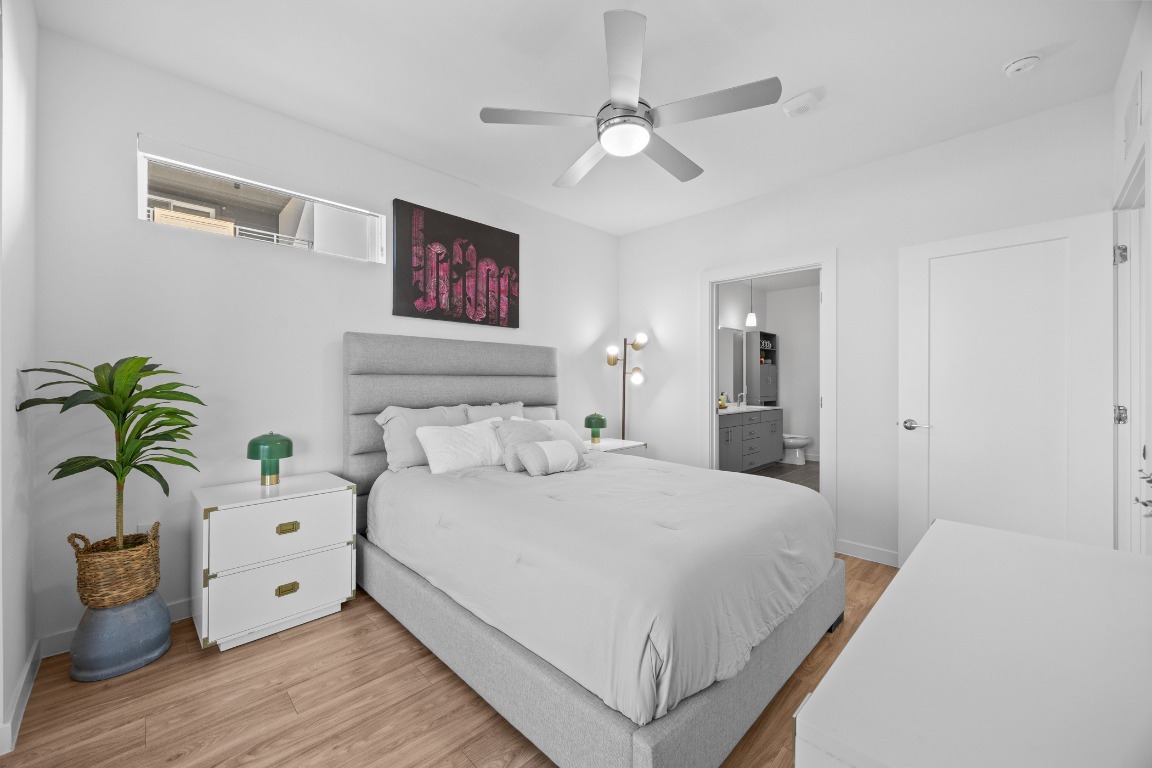 4801 Springdale Road, Unit 1401 Austin, TX 78723 - Photo 20 of 40 a bedroom with a large bed and a chandelier