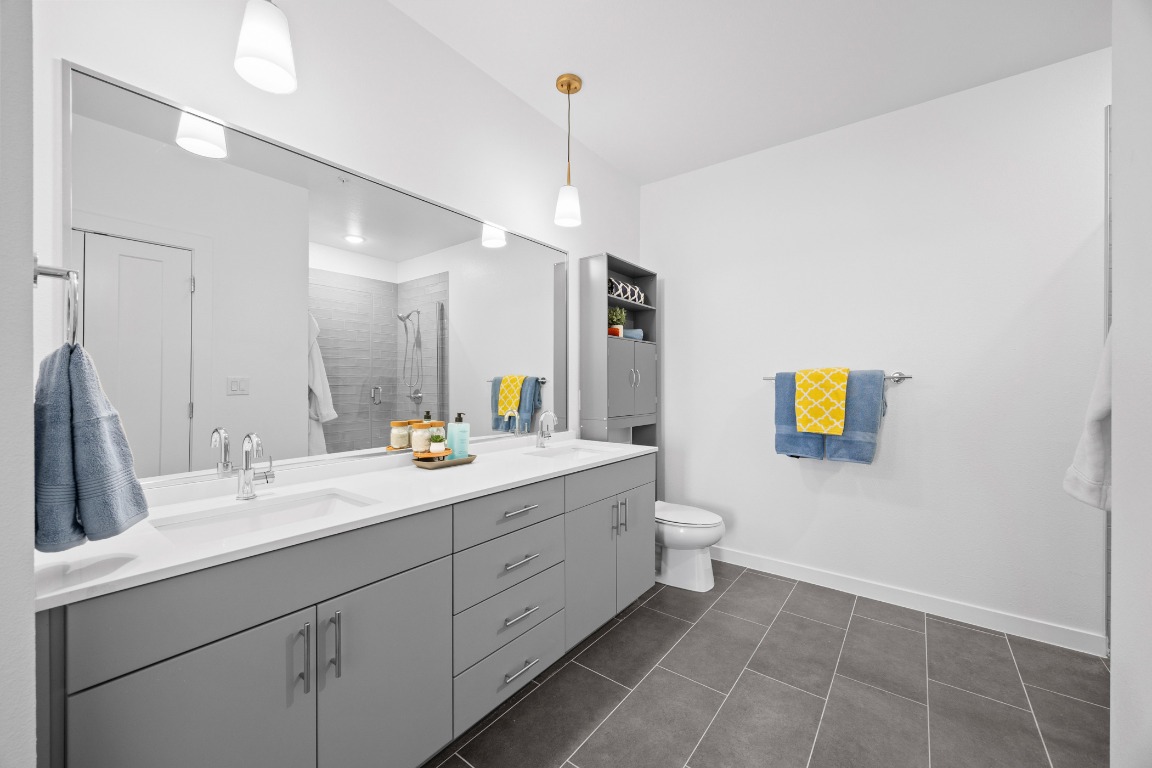 4801 Springdale Road, Unit 1401 Austin, TX 78723 - Photo 9 of 40 a bathroom with a sink a toilet and mirror