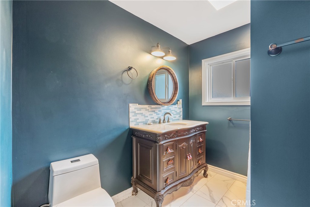 14844 Lull Street Van Nuys, CA 91405 - Photo 22 of 31 a bathroom with a toilet a sink and mirror