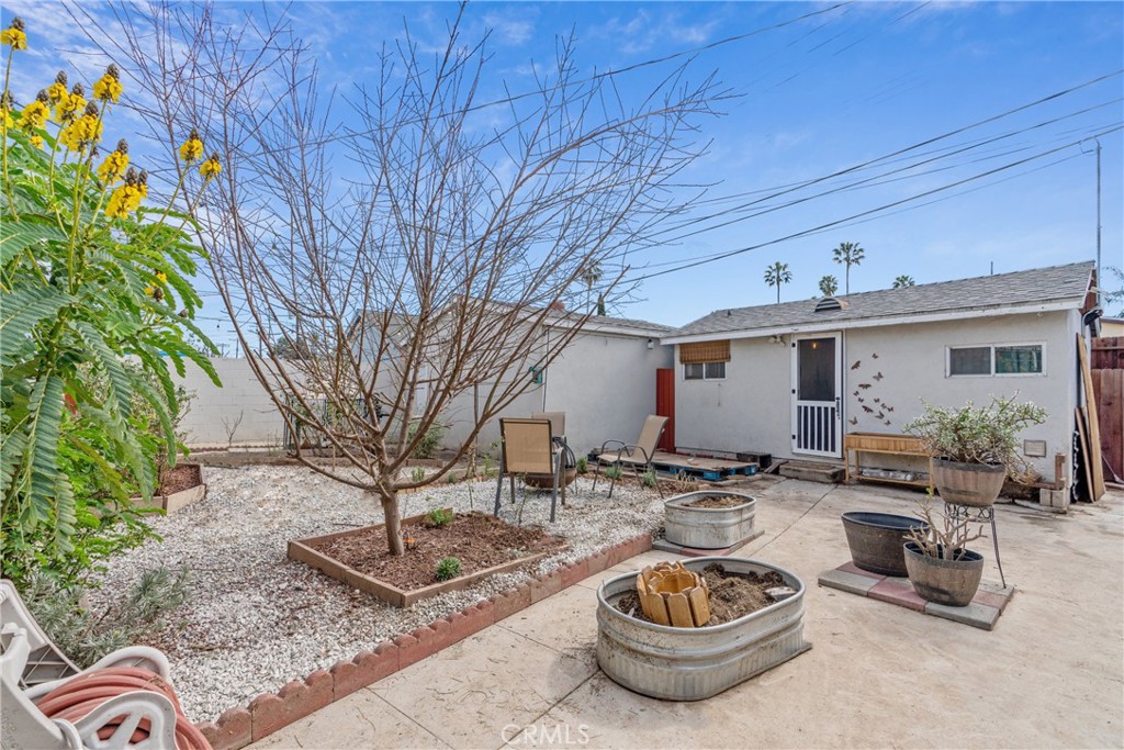 14844 Lull Street Van Nuys, CA 91405 - Photo 27 of 31 a view of a backyard with table and chairs potted plants and wooden fence