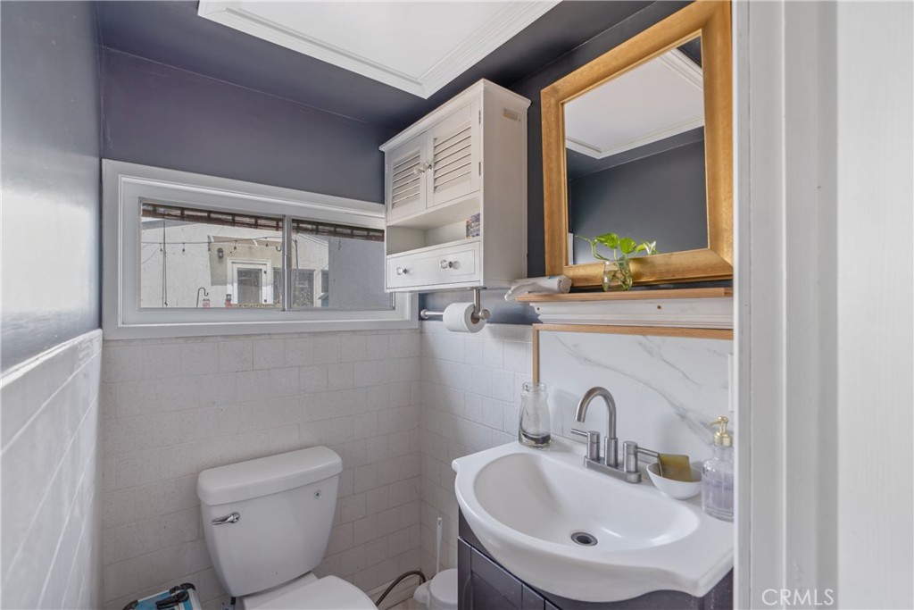 14844 Lull Street Van Nuys, CA 91405 - Photo 30 of 31 a bathroom with a toilet sink and mirror