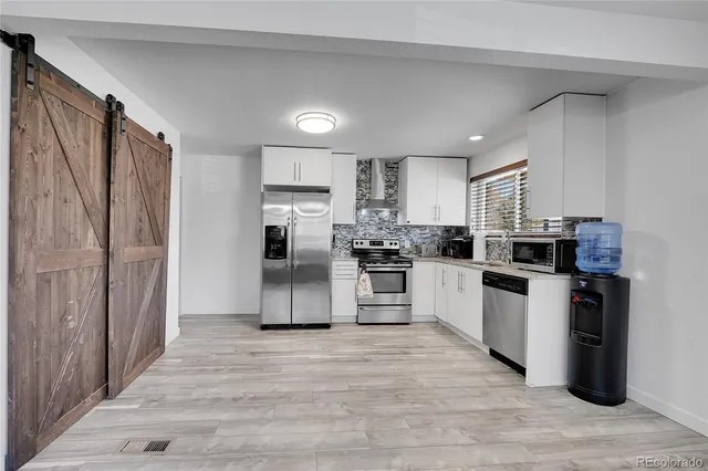 a kitchen with stainless steel appliances a refrigerator sink and microwave