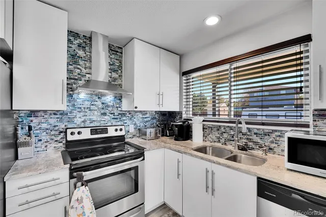 a kitchen with stainless steel appliances a stove a sink and a microwave