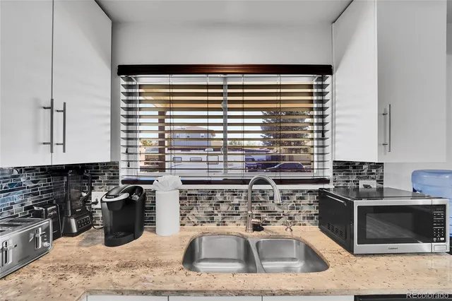 a kitchen with a sink a stove and cabinets
