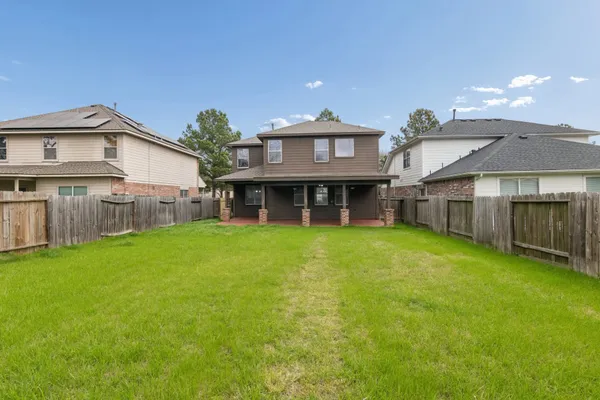 a view of an house with backyard space and balcony