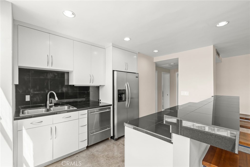 100 Atlantic Avenue, Unit 604 Long Beach, CA 90802 - Photo 5 of 29 a kitchen with stainless steel appliances granite countertop a sink a stove and a refrigerator