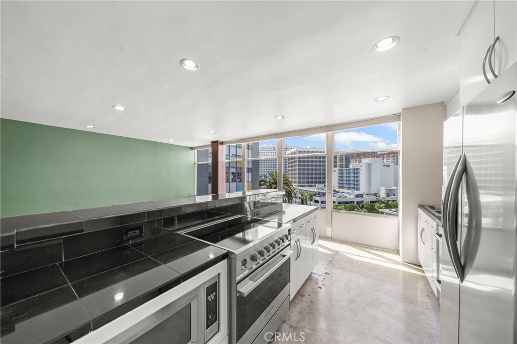 100 Atlantic Avenue, Unit 604 Long Beach, CA 90802 - Photo 6 of 29 a view of a kitchen with a sink and dishwasher a stove top oven with wooden floor