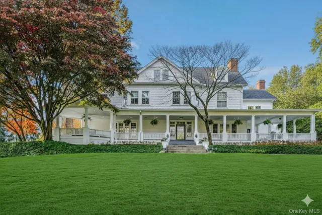 a front view of a house with a garden and trees