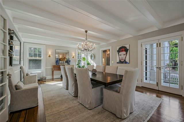 a dining room with furniture a chandelier and wooden floor