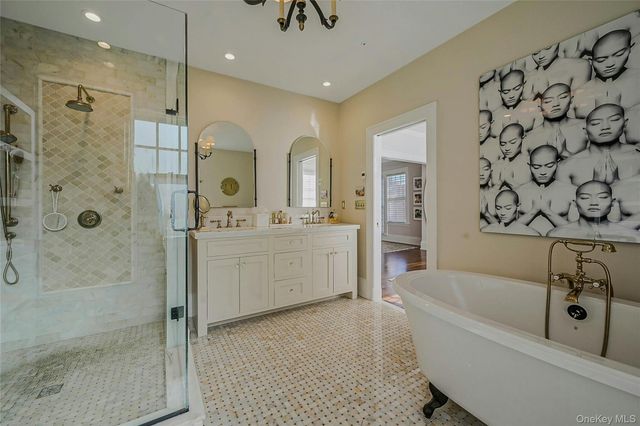 a bathroom with a bathtub a shower a sink and mirror