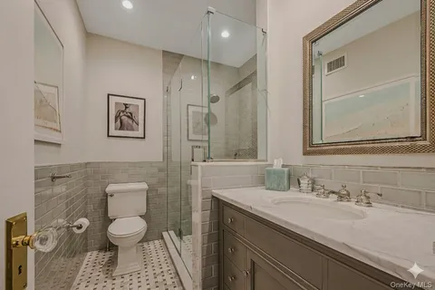 a bathroom with a granite countertop sink a toilet and a mirror