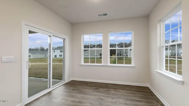 a view of empty room with wooden floor and fireplace