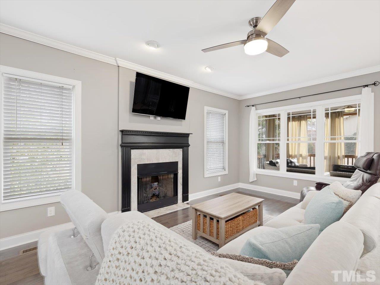 911 Wade Avenue Raleigh, NC 27605 - Photo 12 of 60 a living room with furniture a flat screen tv and a fireplace