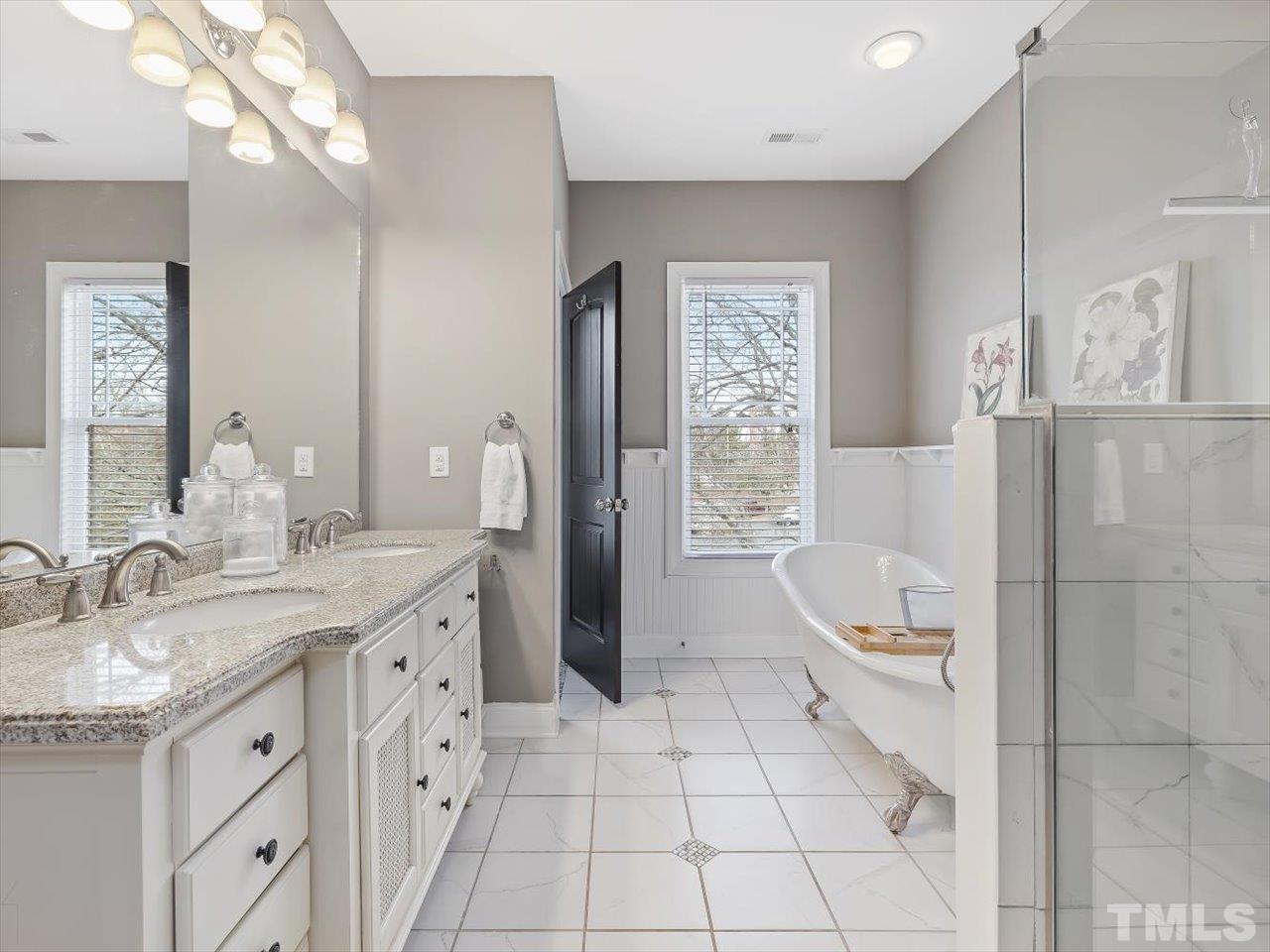 911 Wade Avenue Raleigh, NC 27605 - Photo 34 of 60 a spacious bathroom with a granite countertop sink a toilet a mirror and shower