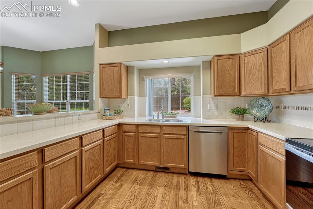 4601 Rowell Point Colorado Springs, CO 80923 - Photo 11 of 48 The well-appointed kitchen boasts a convenient double sink with an elegant tile backsplash perfectly complementing the natural wood tones