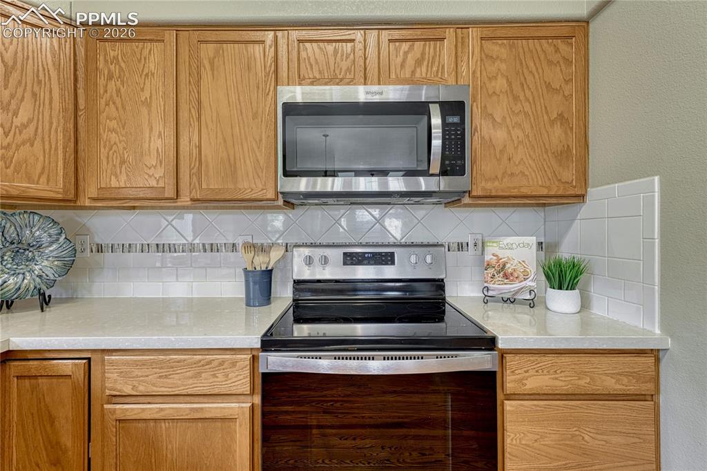 4601 Rowell Point Colorado Springs, CO 80923 - Photo 12 of 48 Enjoy modern cooking conveniences with a built-in microwave and an electric glass-top range. The pristine quartz countertops offer plenty of prep space for any meal