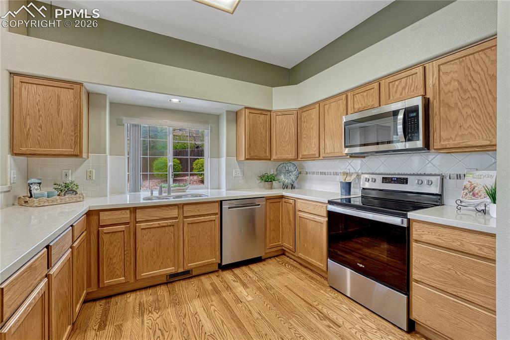 4601 Rowell Point Colorado Springs, CO 80923 - Photo 10 of 48 This kitchen is a foodie's dream, featuring ample wood cabinetry and sleek quartz countertops