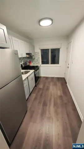 a kitchen with a refrigerator and a stove top oven