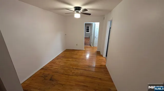 a view of a hallway with a chandelier fan and wooden floor