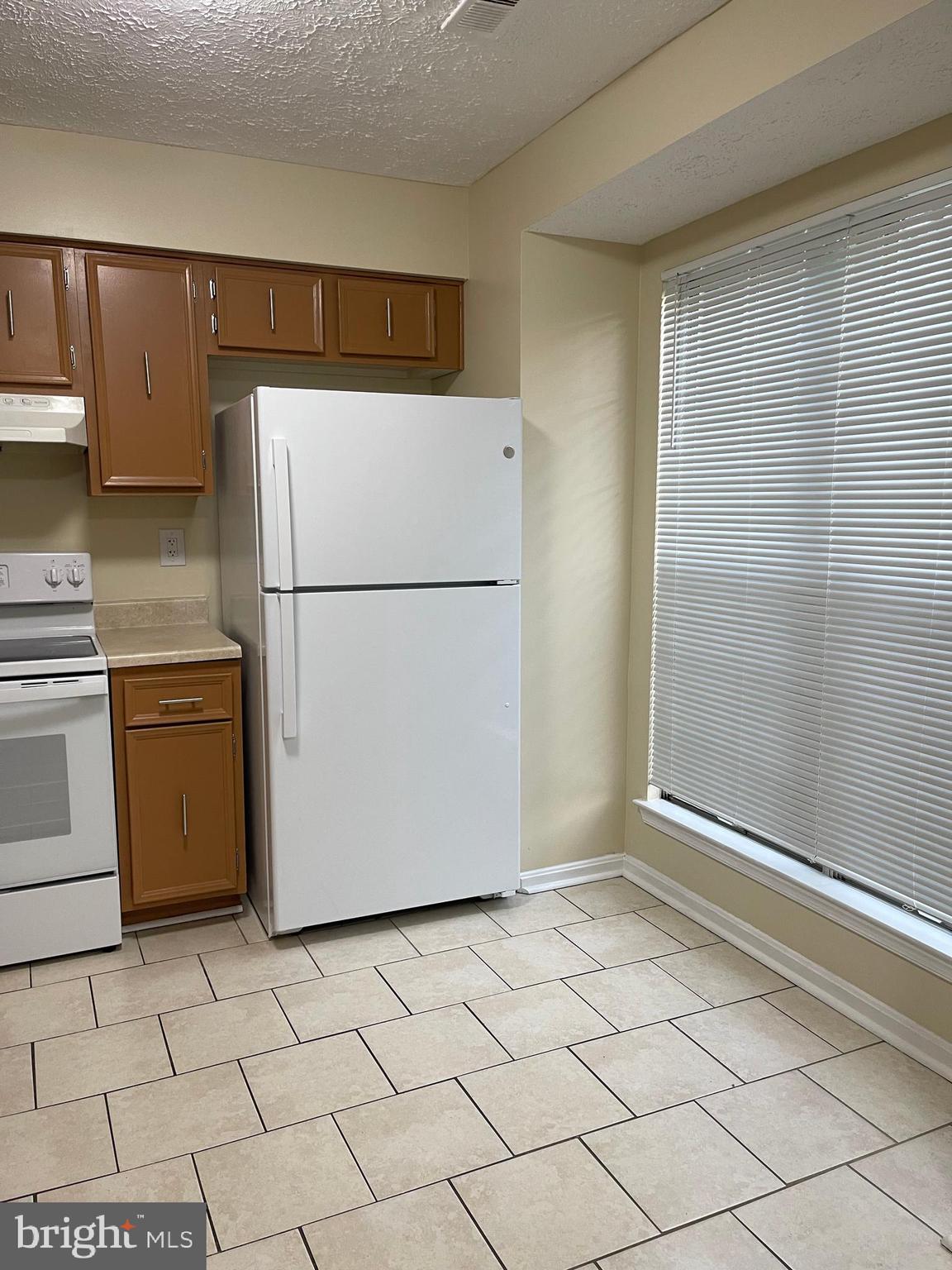 2420 Rosecroft Court Oxon Hill, MD 20745 - Photo 29 of 29 a white refrigerator freezer and a stove sitting inside of a kitchen
