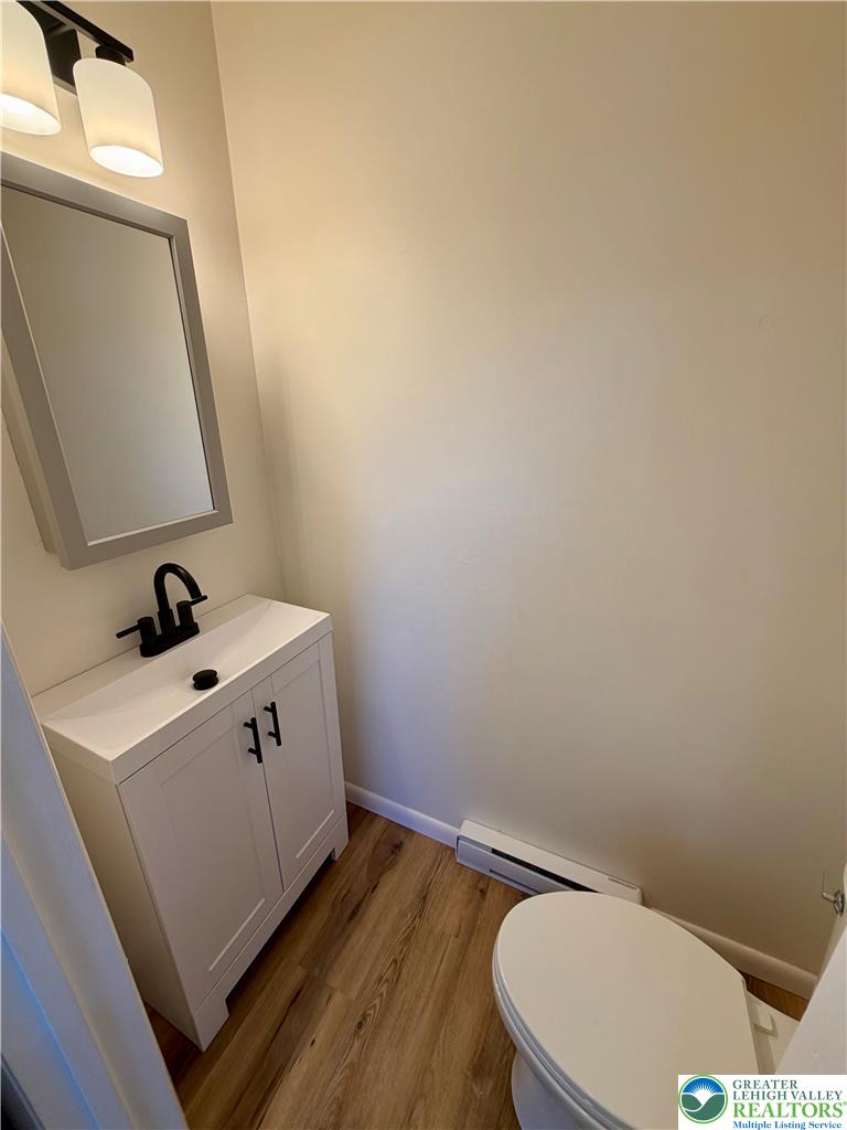 3508 Nazareth Road Easton, PA 18045 - Photo 20 of 25 A well-lit, compact 1/2 bathroom off the main bedroom features a vanity with a sleek black faucet and wood-look flooring.