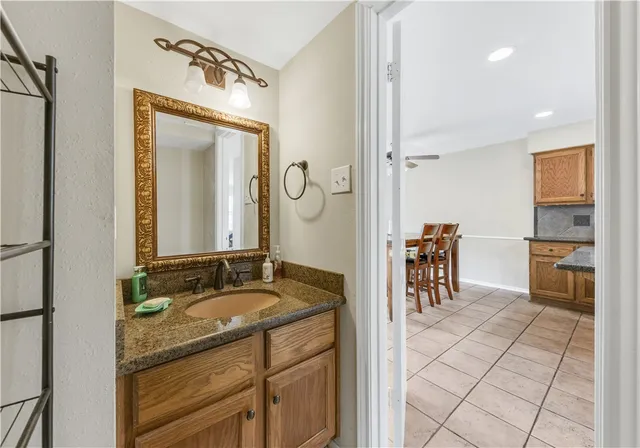 a spacious bathroom with a granite countertop sink a mirror and a shower