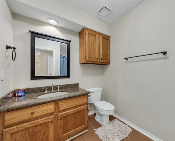 a bathroom with a toilet a sink and mirror