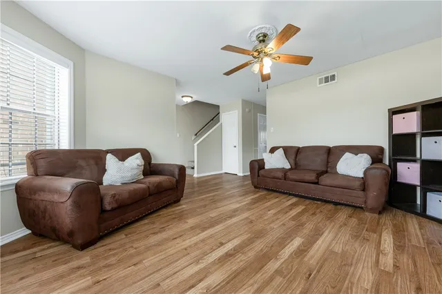 a living room with furniture and a wooden floor