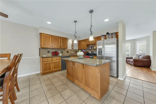 a kitchen with stainless steel appliances granite countertop a refrigerator and a stove top oven