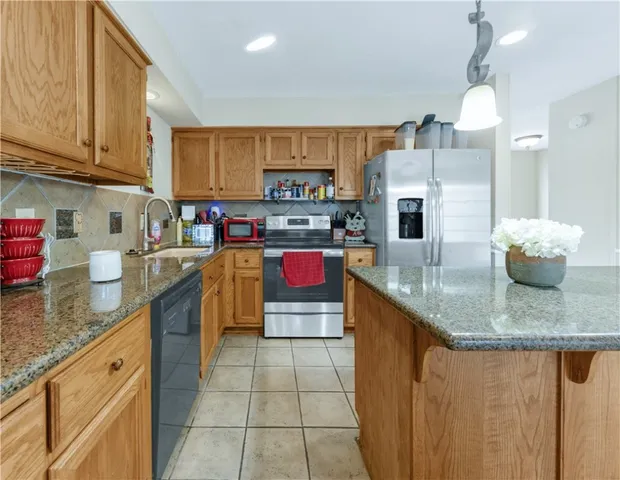 a kitchen with stainless steel appliances granite countertop a sink counter space cabinets and a stove
