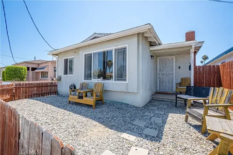 a backyard of a house with barbeque oven table and chairs
