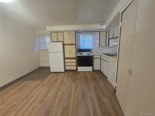a kitchen with white cabinets and refrigerator
