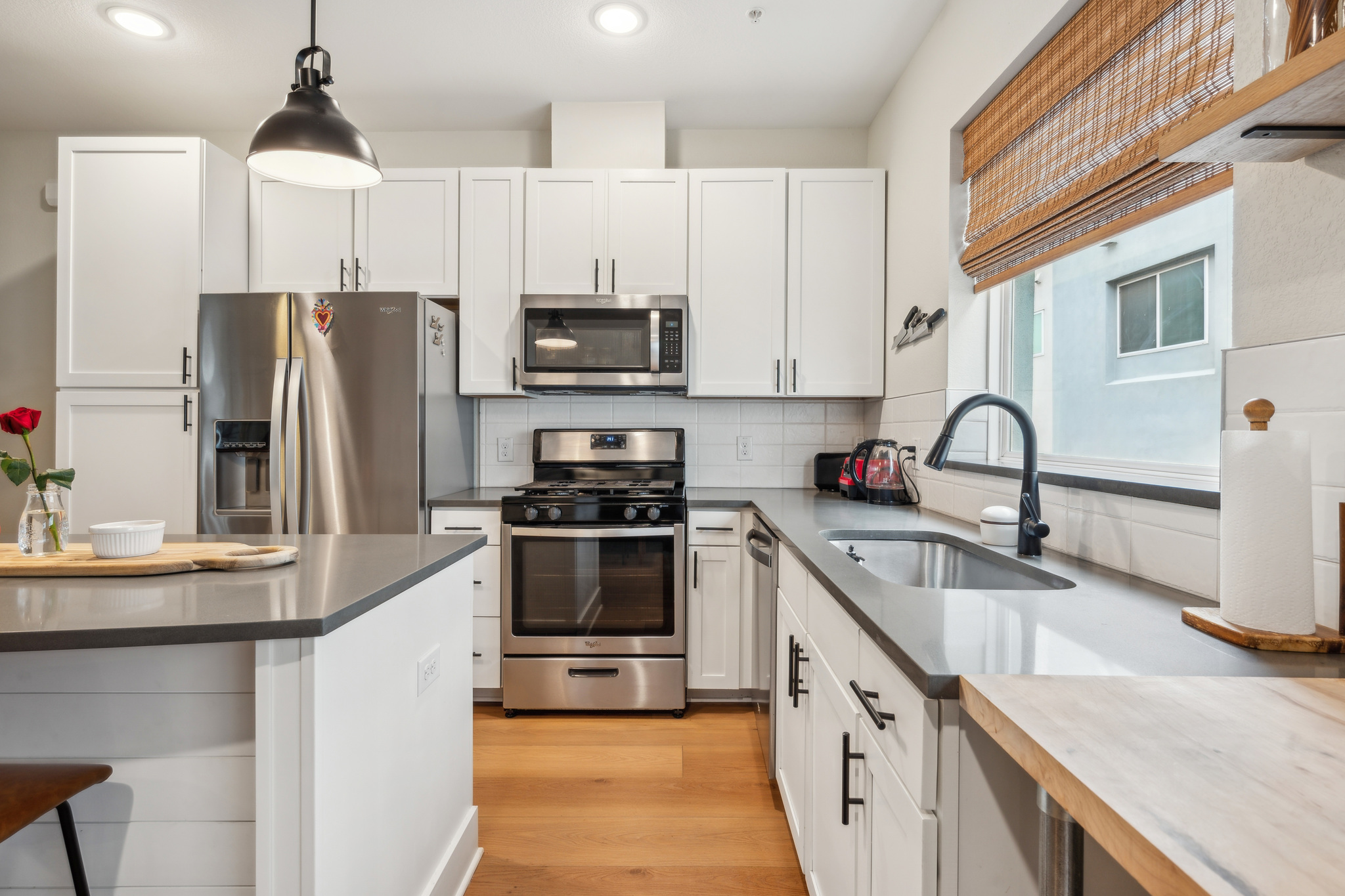 2827 Manor Road, Unit 3104 Austin, TX 78722 - Photo 1 of 30 A contemporary kitchen showcasing sleek stainless steel appliances and light wood flooring.