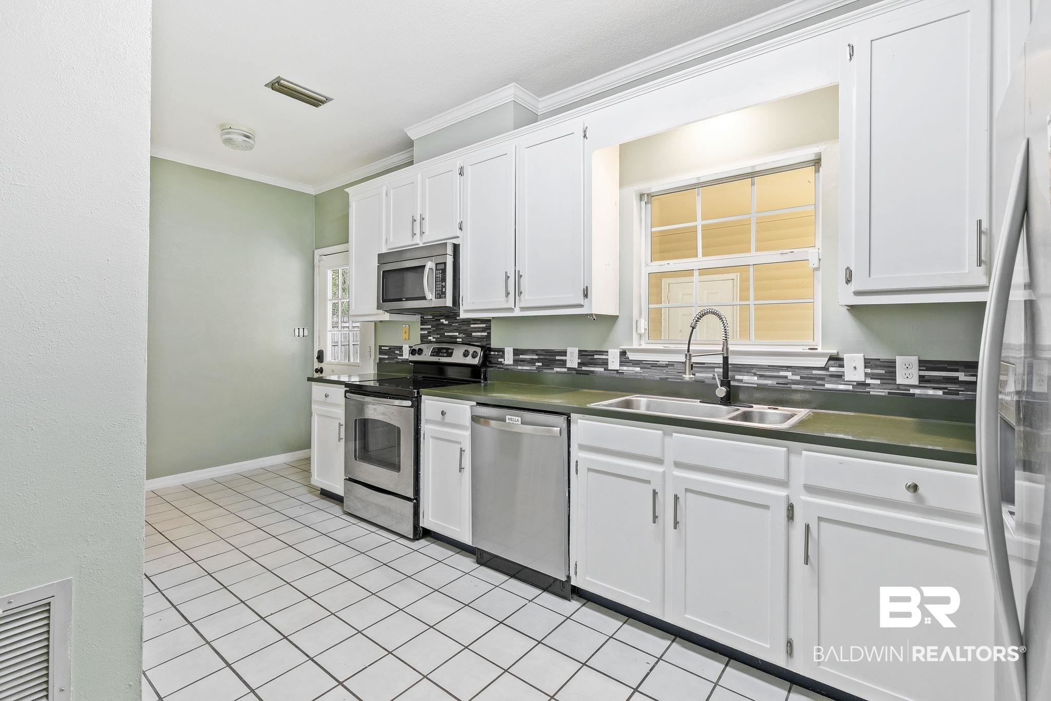 474 Ridgewood Drive Daphne, AL 36526 - Photo 20 of 57 Kitchen featuring white cabinets, stainless steel appliances, and sink