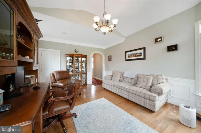 a living room with furniture a flat screen tv and a floor to ceiling window