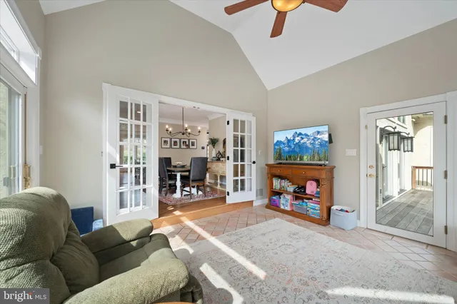 a kitchen with stainless steel appliances granite countertop a refrigerator a sink a stove a dining table and chairs