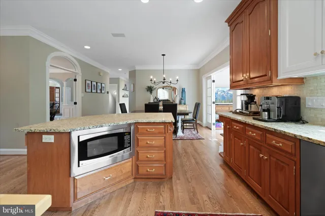 a kitchen with stainless steel appliances kitchen island granite countertop a stove and a large window