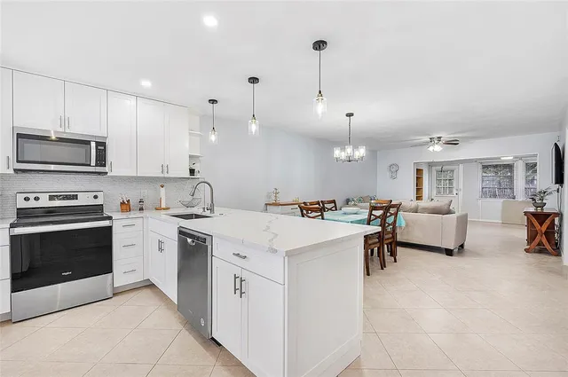 a large white kitchen with lots of counter space and a sink