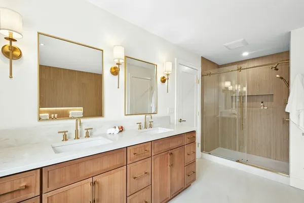 a bathroom with a double vanity sink mirror double and shower