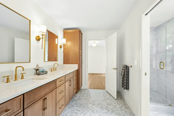 a spacious bathroom with a double vanity sink mirror and shower