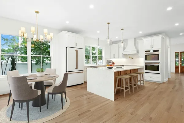 a view of a dining room and livingroom with furniture wooden floor a chandelier