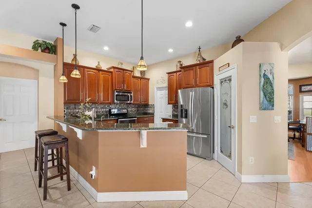 a kitchen with stainless steel appliances granite countertop a refrigerator a oven a sink and a stove