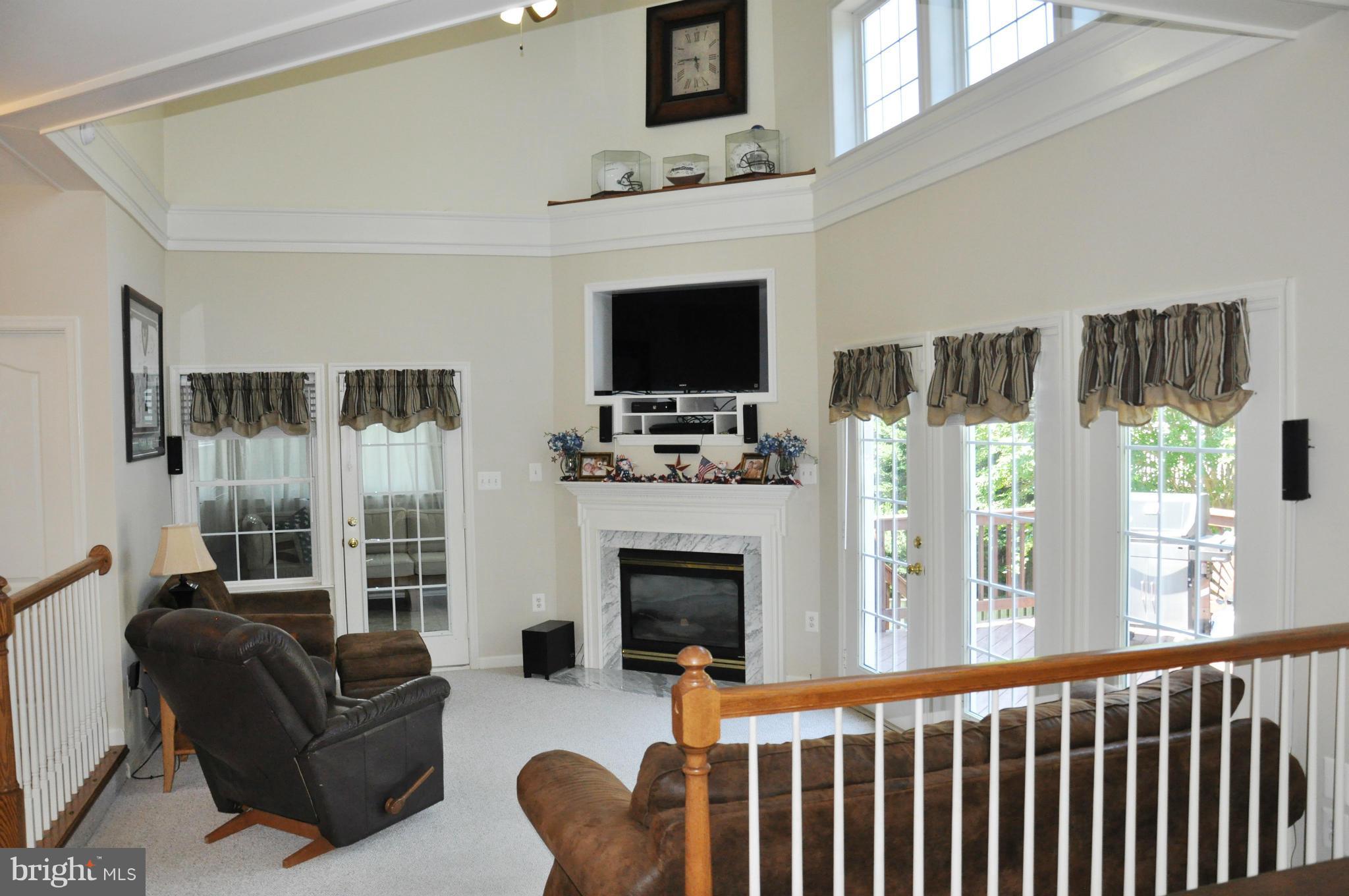 2585 Bear Den Road Frederick, MD 21701 - Photo 12 of 30 a living room with furniture a flat screen tv and a fireplace
