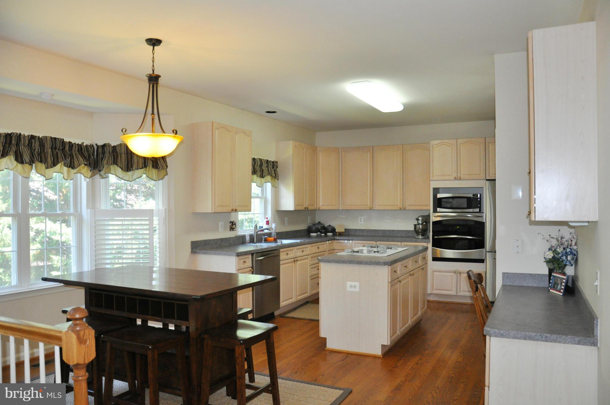 2585 Bear Den Road Frederick, MD 21701 - Photo 13 of 30 a kitchen with kitchen island granite countertop a stove a sink and a wooden floors